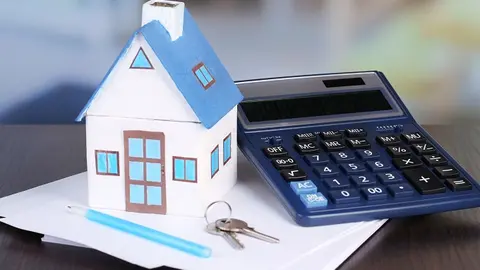 Toy house and calculator on table close-up