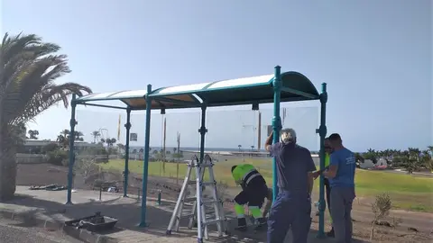 Operarios arreglando una marquesina.